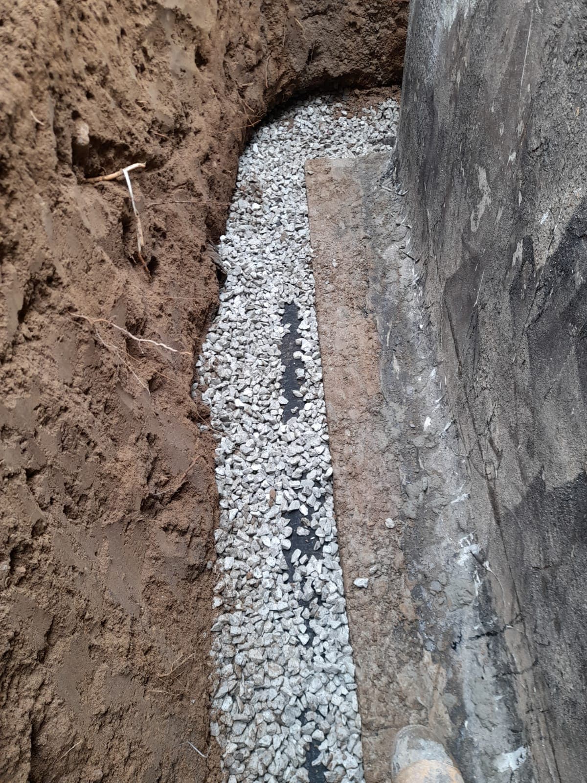 Exterior waterproofing trench that drives per-linear-foot cost